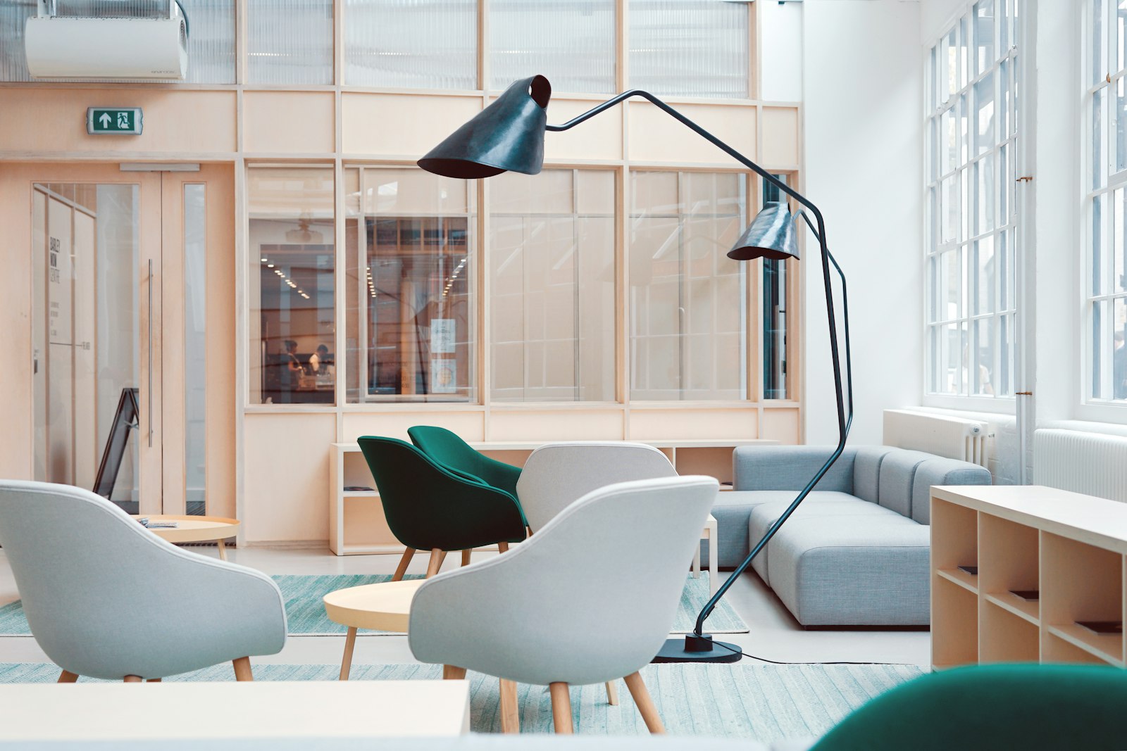 A quiet, light-filled meeting area with armchairs and a floor lamp